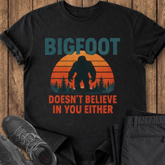 Black t-shirt with Bigfoot graphic and text on a wooden surface