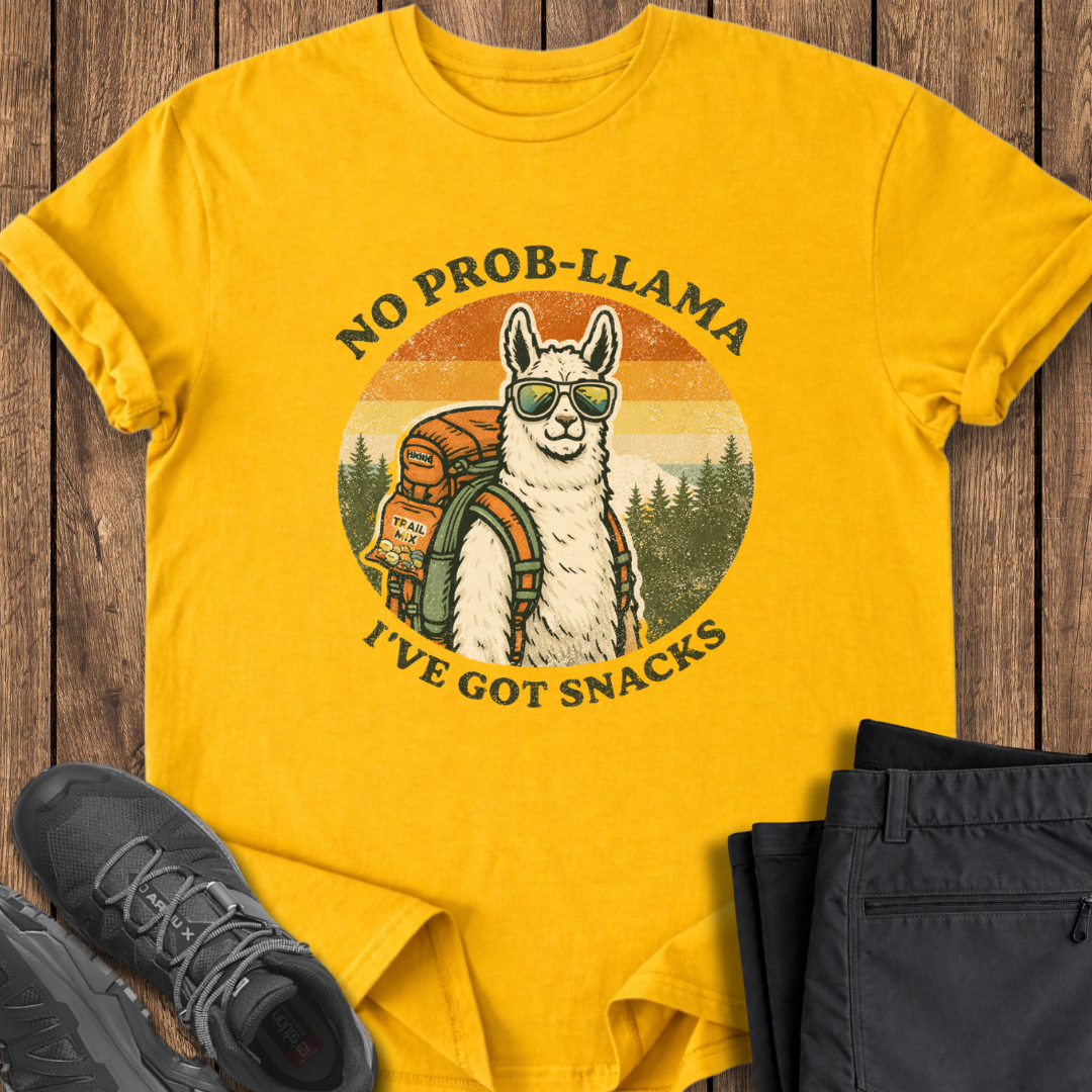 Yellow t-shirt with a llama graphic and text on a wooden surface with shoes and pants. funny outdoor shirt