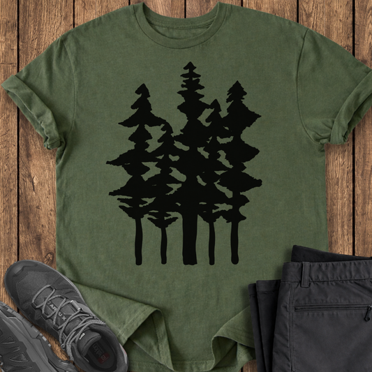 Green t-shirt with black tree design on a wooden surface with shoes and pants.