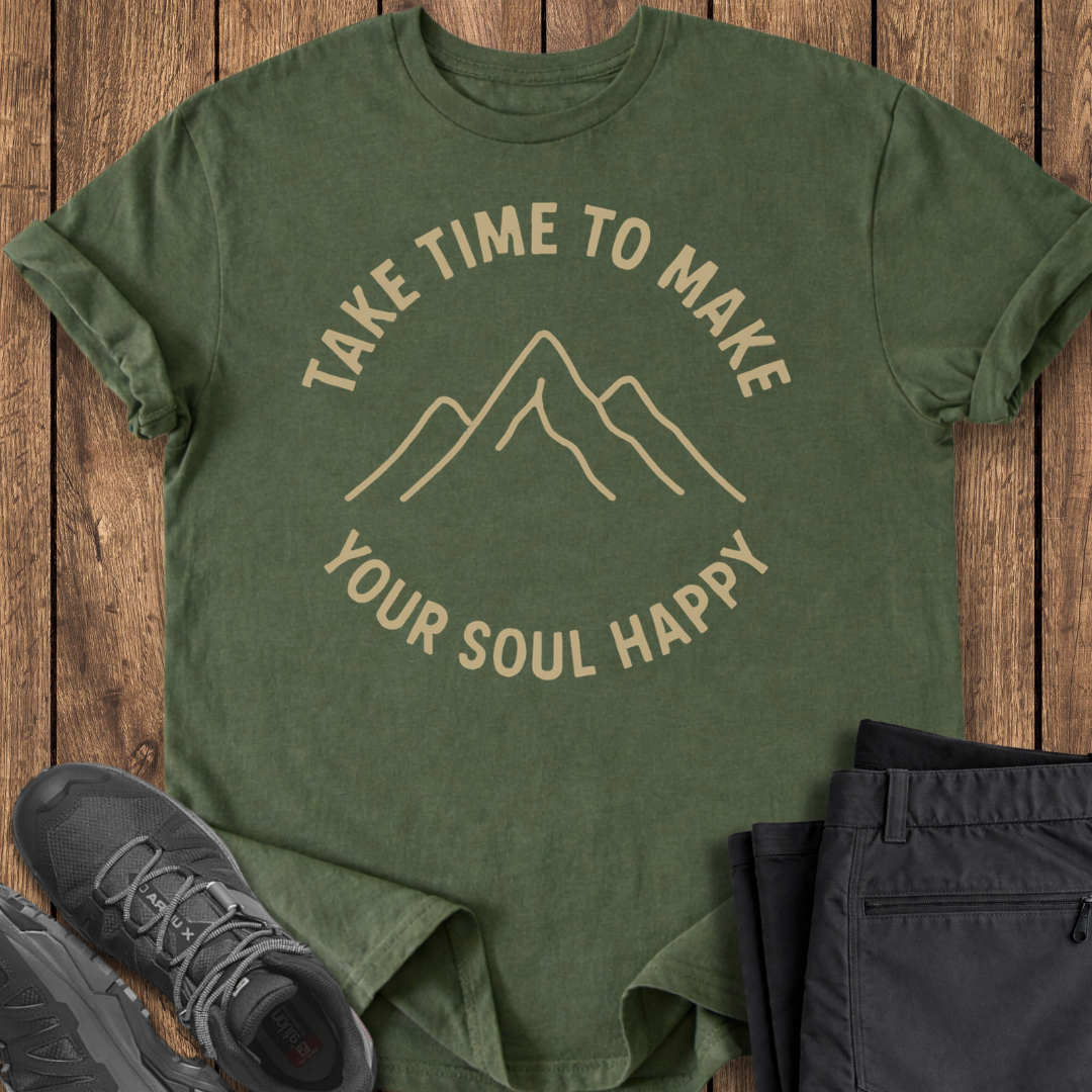 Green t-shirt with motivational quote on a wooden surface with shoes and pants.