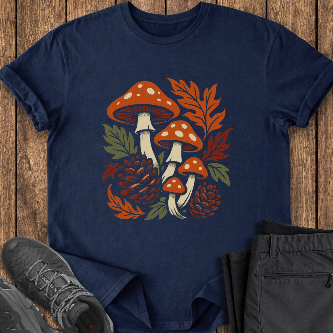 Navy blue t-shirt with mushroom design on a wooden surface with shoes and pants. foraging mushroom hunting t shirt autumn mushroom pinecones