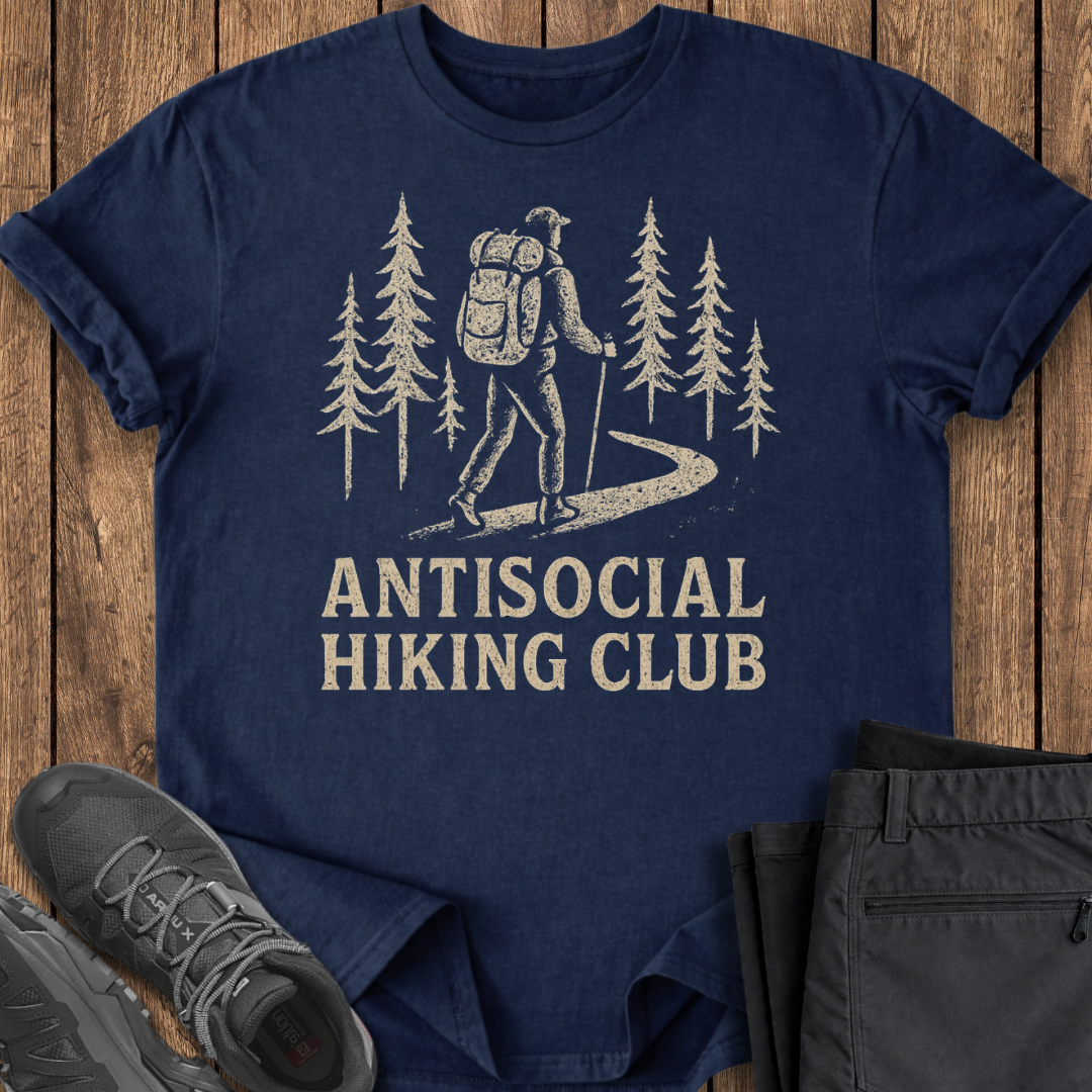 Navy blue t-shirt with 'Antisocial Hiking Club' graphic on a wooden surface with shoes and pants.