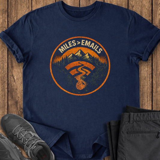 Navy blue t-shirt with orange graphic design on a wooden surface with shoes and pants. hiking t shirt