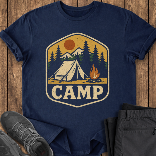Navy blue t-shirt with 'CAMP' graphic on a wooden surface with shoes and pants.