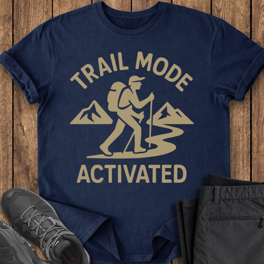 Navy blue t-shirt with 'Trail Mode Activated' graphic on a wooden surface with hiking shoes and pants.