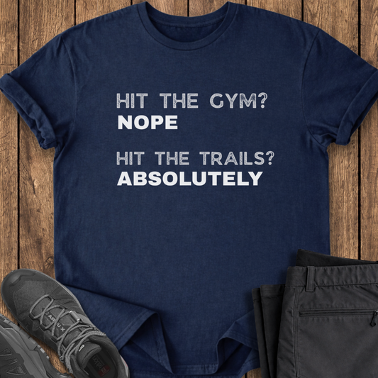 Navy blue t-shirt with humorous text on a wooden surface with shoes and pants.