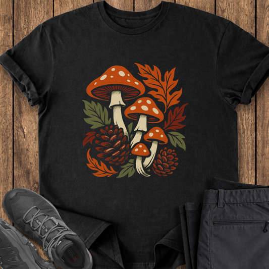 Black t-shirt with autumn-themed design featuring mushrooms and leaves on a wooden surface. mycology foraging fall t shirt