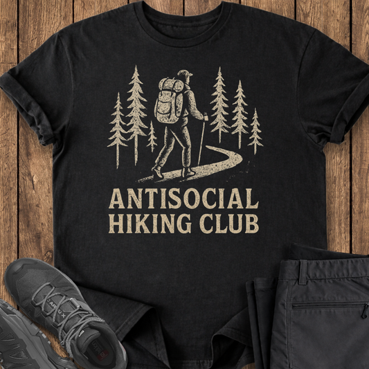 Black t-shirt with 'Antisocial Hiking Club' graphic on a wooden surface with hiking shoes and pants.