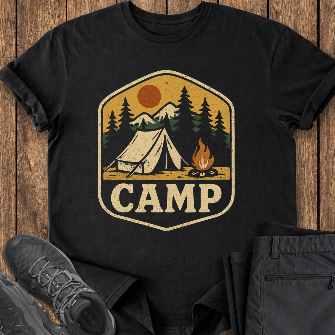 Black t-shirt with camping graphic and 'CAMP' text on a wooden surface