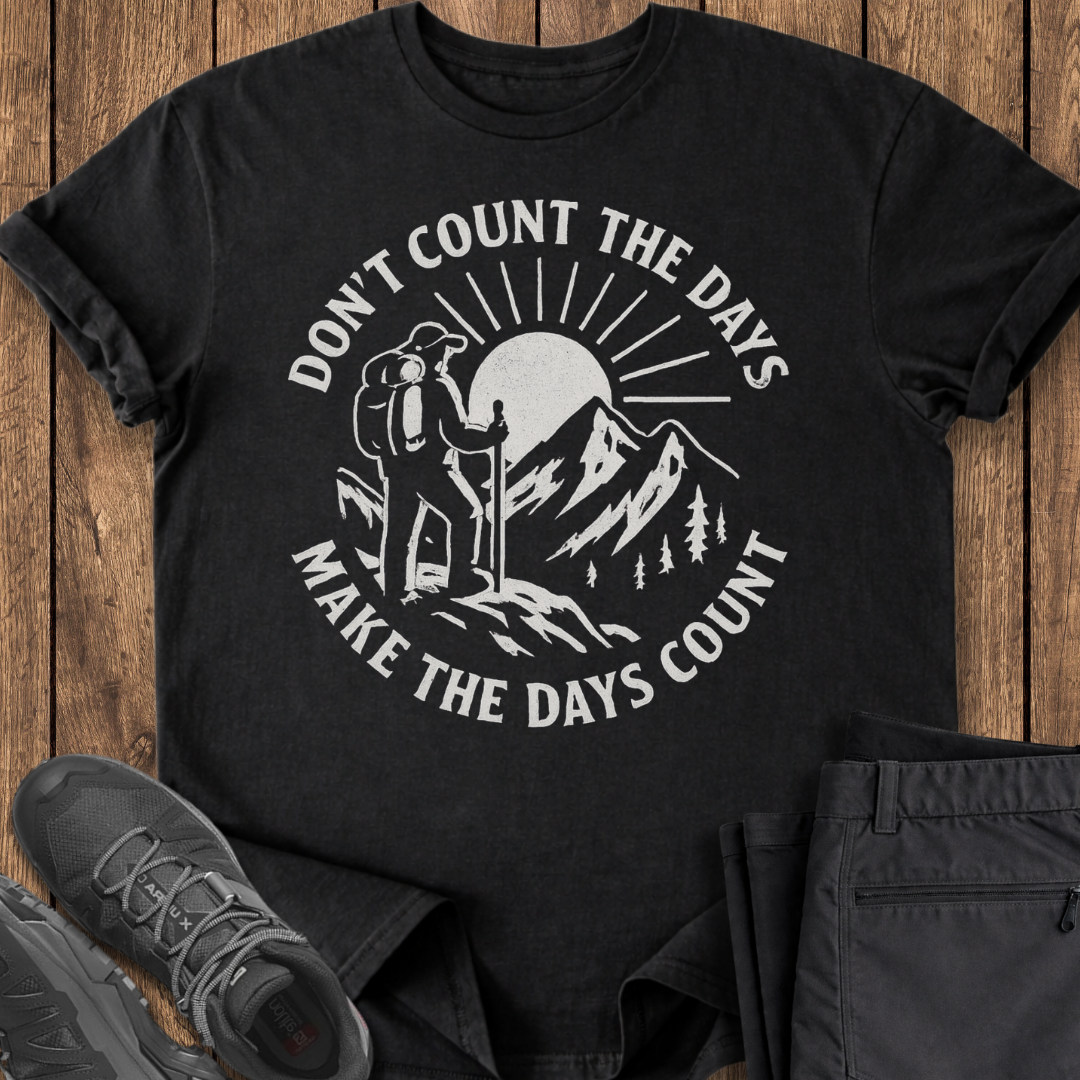 Black t-shirt with outdoor graphic and text on a wooden surface