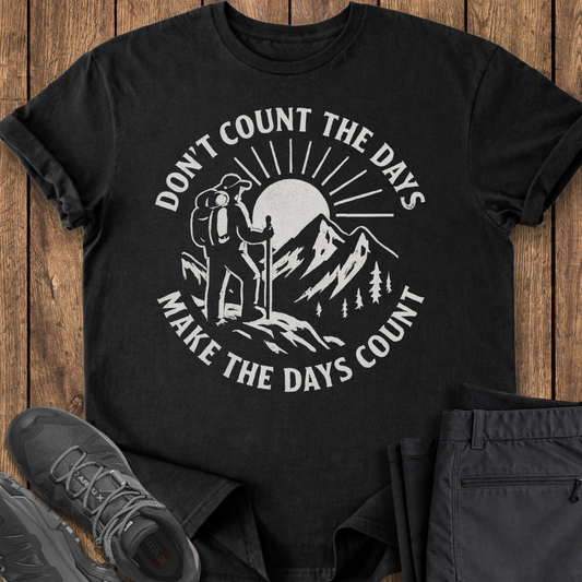 Black t-shirt with outdoor graphic and text on a wooden surface