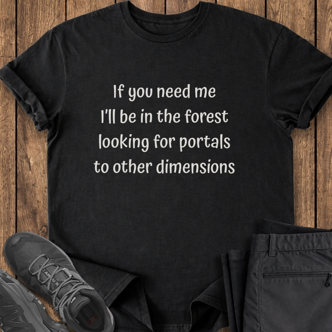 Black t-shirt with humorous text on a wooden surface with shoes and pants. funny hiking exploring t shirt