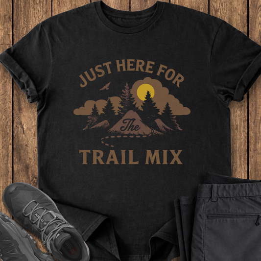 Black t-shirt with nature-themed graphic and text 'Just Here for the Trail Mix' on a wooden surface. funny hiking shirt