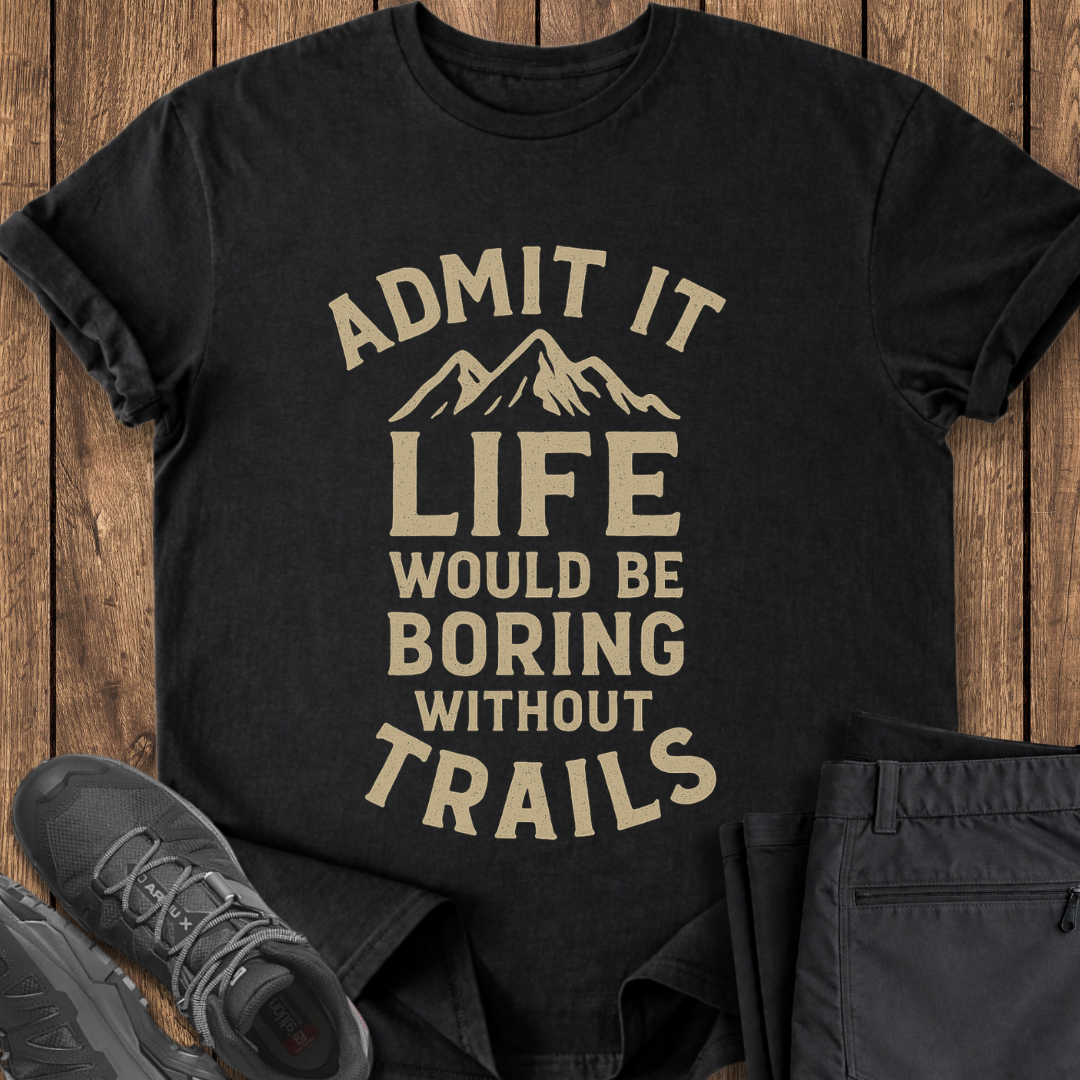 Black t-shirt with 'Admit it, life would be boring without trails' text on a wooden surface with shoes and pants. hiking t shirt