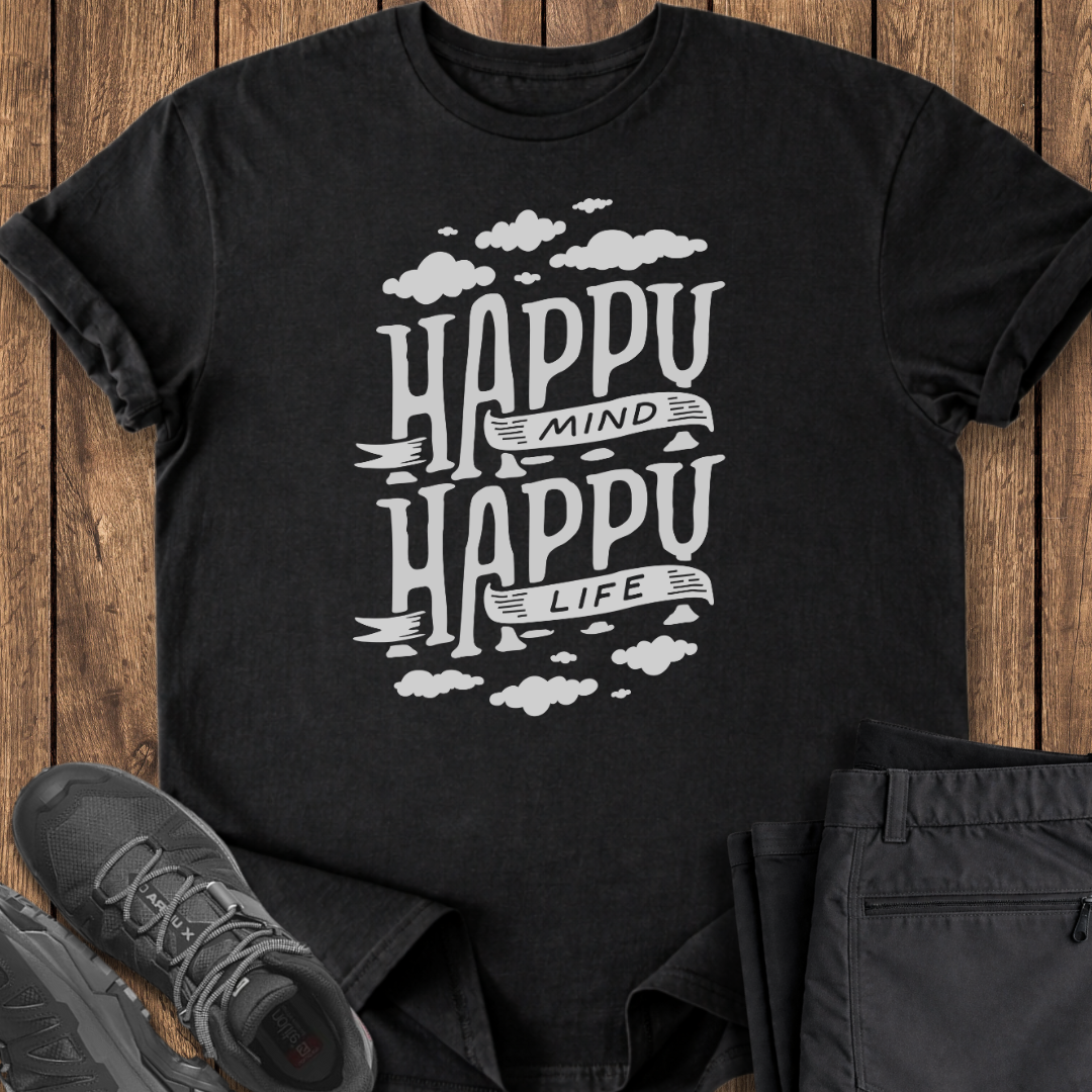 Black t-shirt with 'Happy Mind Happy Life' text on a wooden surface with shoes and pants.