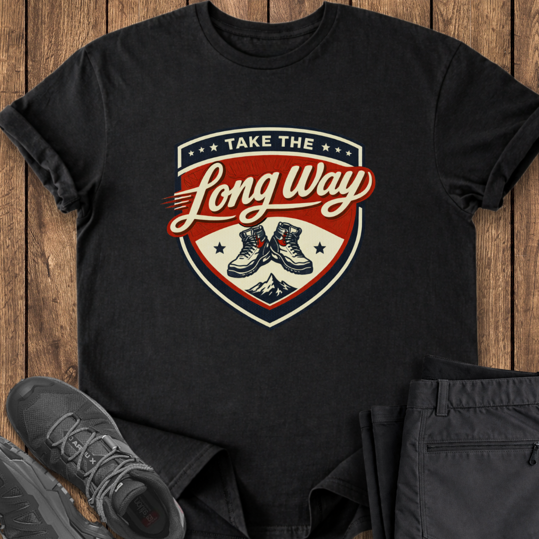 Black t-shirt with 'Take the Long Way' graphic design on a wooden surface with shoes and pants. hiking t shirts