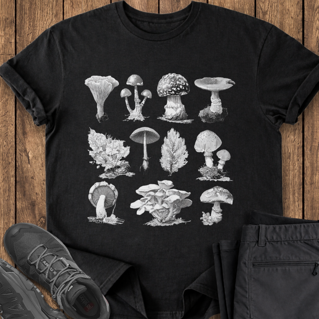Black t-shirt with mushroom illustrations on a wooden surface with shoes and pants. vintage mushroom specimen t shirt