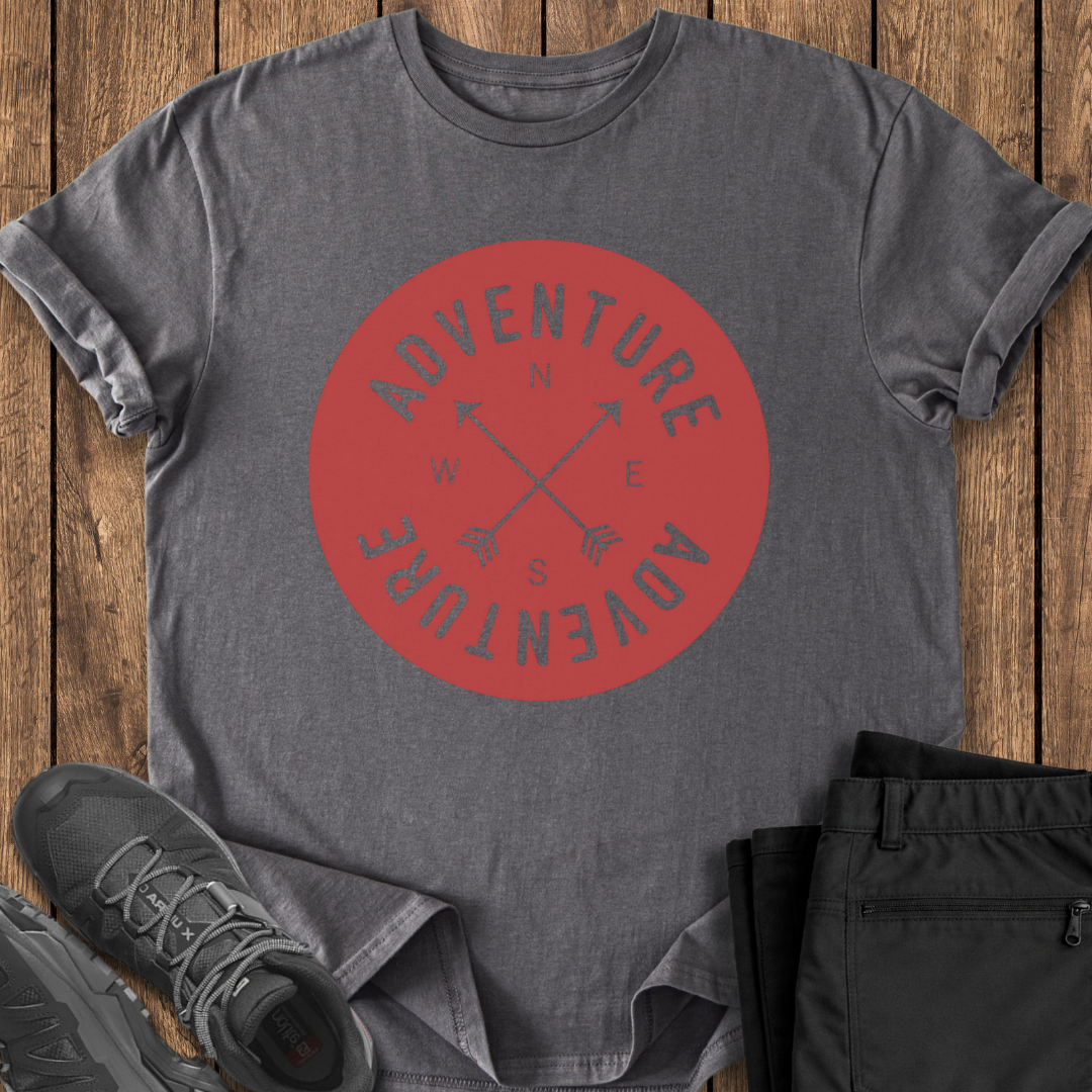 Gray t-shirt with red 'Adventure' graphic on a wooden surface with shoes and pants.