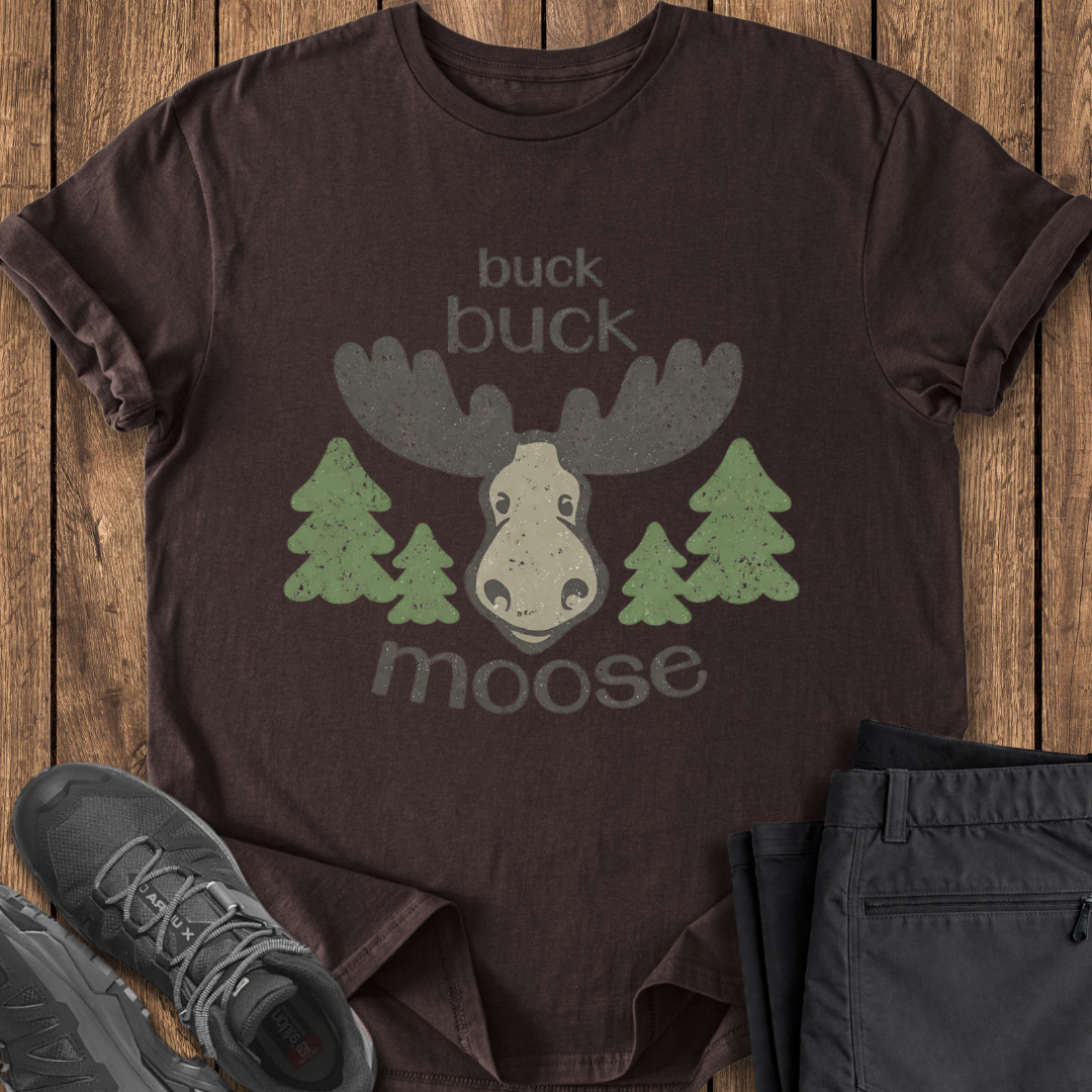 Brown t-shirt with moose graphic and text on a wooden surface funny moose