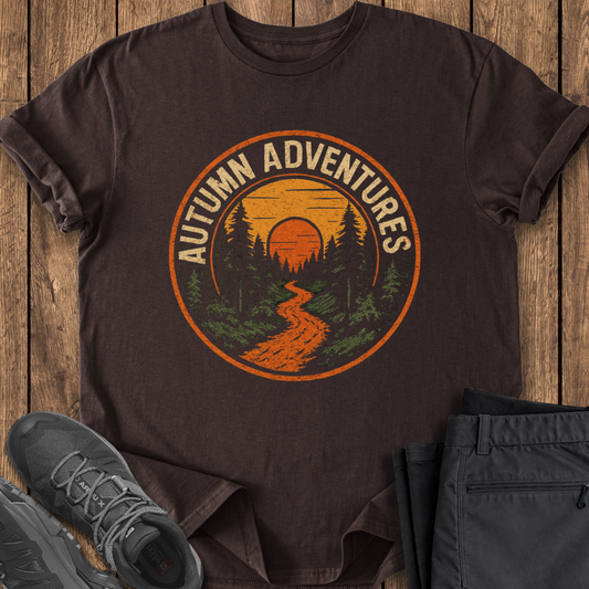 Brown t-shirt with 'Autumn Adventures' graphic on a wooden surface with shoes and pants. hiking outdoor t shirt