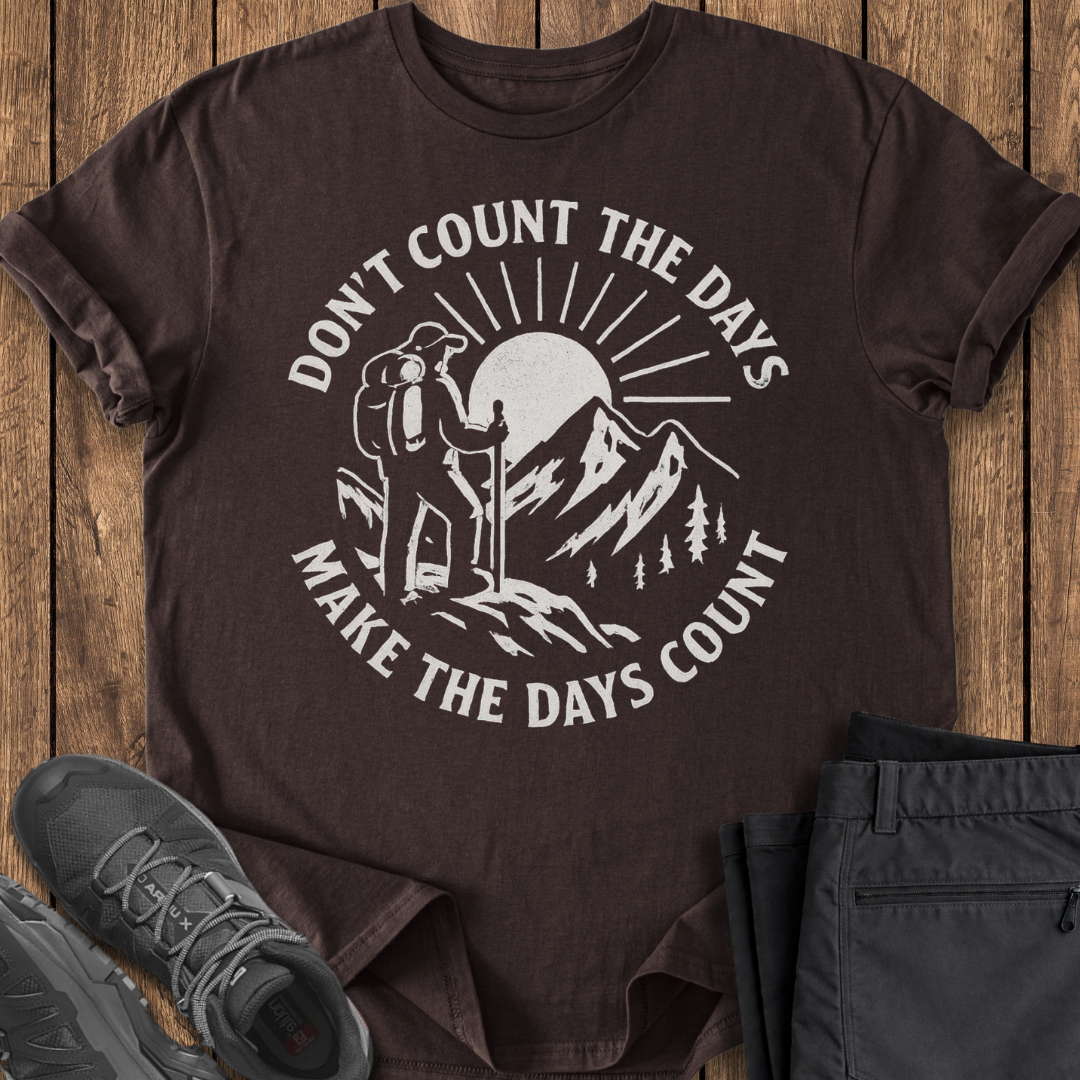 Brown t-shirt with hiking graphic and text on a wooden surface