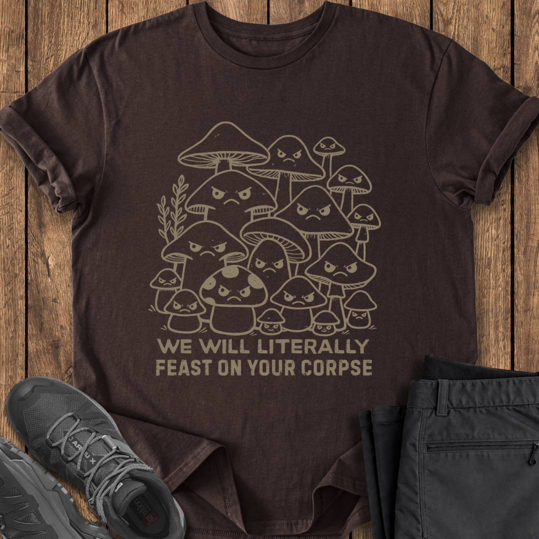 Brown t-shirt with mushroom graphic and text on a wooden surface with shoes and pants.