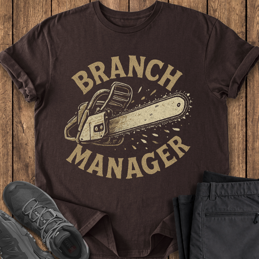 Brown t-shirt with 'Branch Manager' graphic on a wooden surface with shoes and pants. funny chainsaw camping t shirt