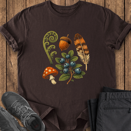 Brown t-shirt with nature-themed design on a wooden surface with shoes and pants.