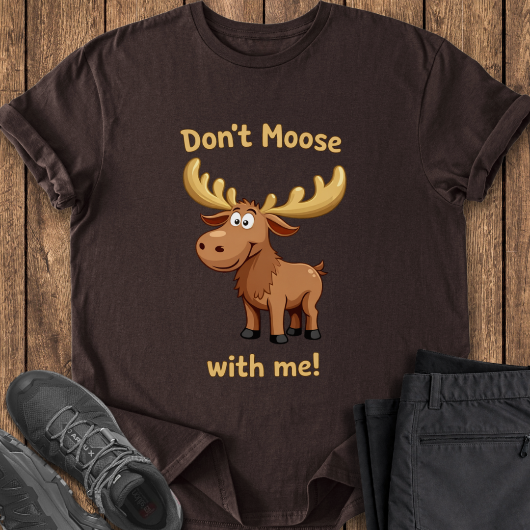 Brown t-shirt with cartoon moose graphic and text on a wooden surface with shoes and pants. cute funny moose dad joke shirt