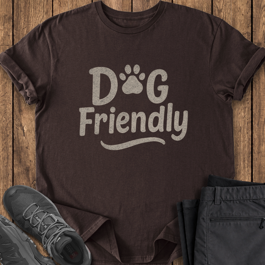 Brown t-shirt with 'DOG FRIENDLY' text on a wooden surface with shoes and pants.