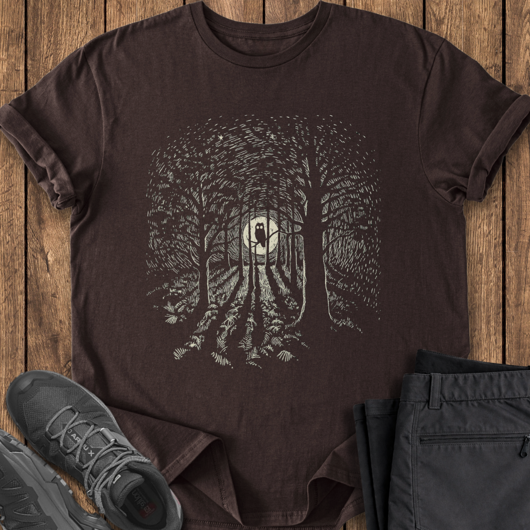 Brown t-shirt with forest design on a wooden surface with shoes and pants. owl hunting owling t shirt