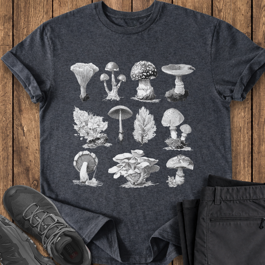 Dark gray t-shirt with mushroom illustrations on a wooden surface with shoes and pants. vingate specimen style