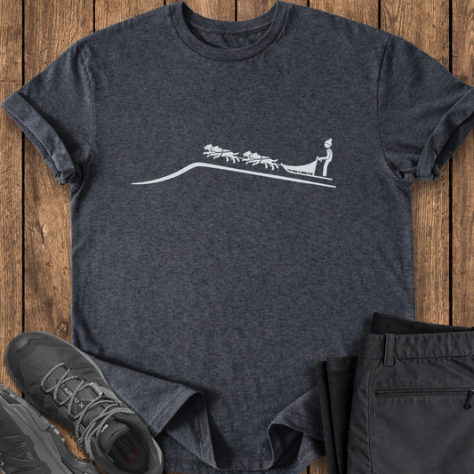 Dark gray t-shirt with a white graphic design on a wooden surface, accompanied by black pants and shoes. dogsledding dog team shirt