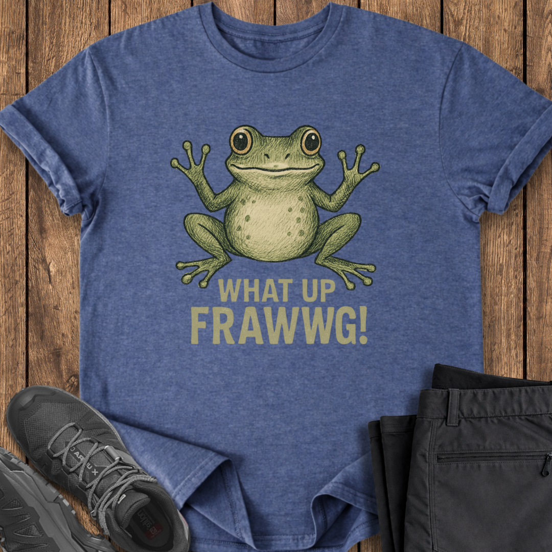 Blue t-shirt with a green frog graphic and text on a wooden surface, with shoes and shorts on either side.