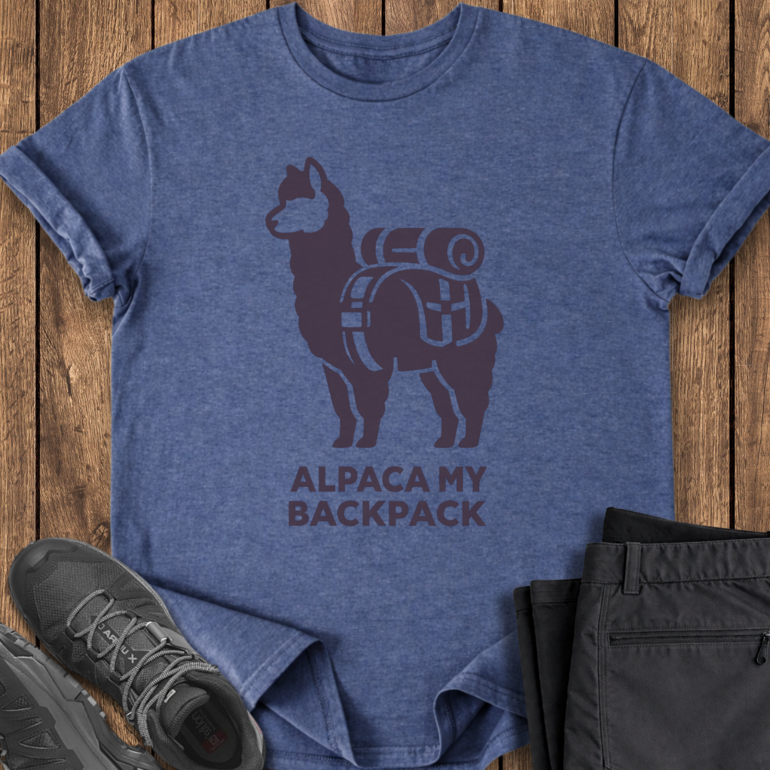 Blue t-shirt with alpaca graphic and 'Alpaca My Backpack' text on a wooden surface, with shoes and pants partially visible. funny backpacking moutain hiking t shirts
