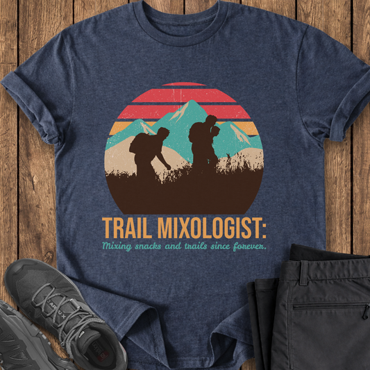 Blue t-shirt with 'Trail Mixologist' graphic on a wooden surface with shoes and shorts. funny hiking mountain t shirt