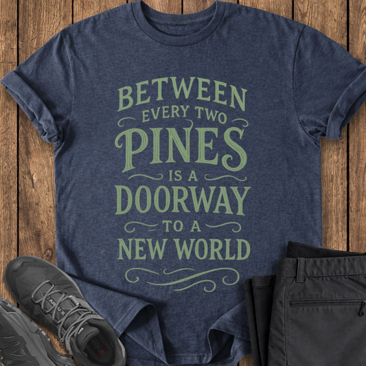 Blue t-shirt with motivational quote on a wooden surface with shoes and pants. john muir quote t shirt hiking