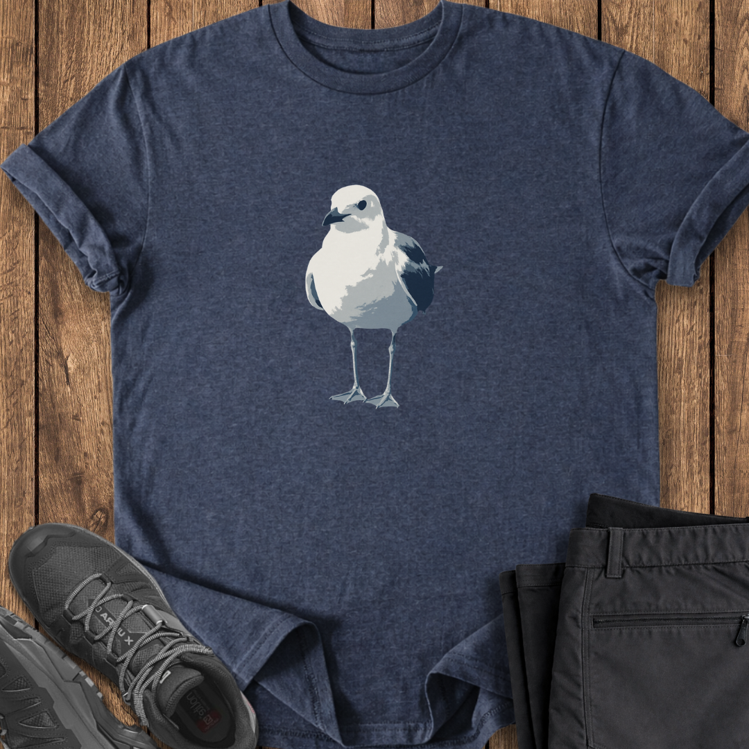Navy blue t-shirt with a bird graphic, black sneakers, and black pants on a wooden surface