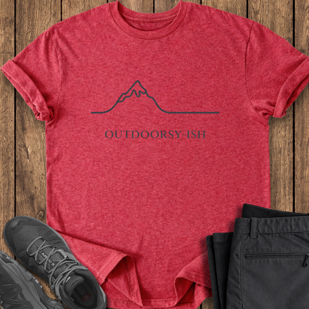 Red t-shirt with 'OUTDOORSY-ISH' text and mountain graphic on a wooden surface, with black pants and shoes. funny hiking t shirts