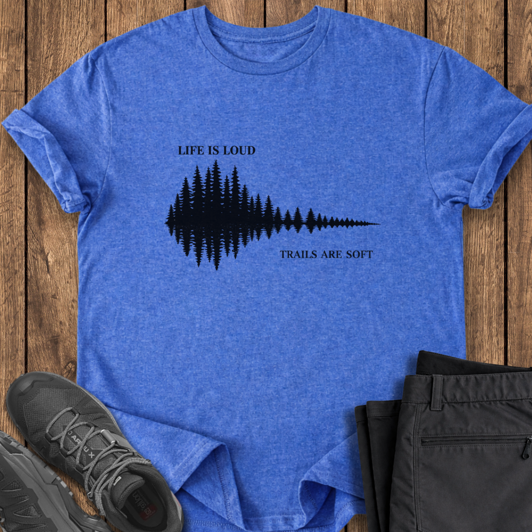 Blue t-shirt with nature-themed design and text on a wooden surface with shoes and pants. hiking t shirts