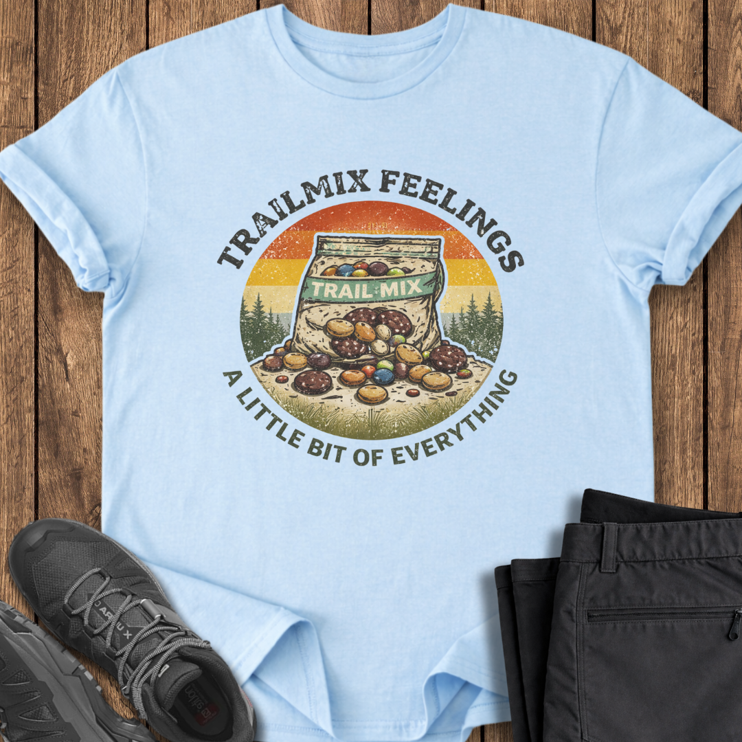 Light blue t-shirt with trail mix graphic and text on a wooden surface with shoes and pants. funny hiking mental health shirt