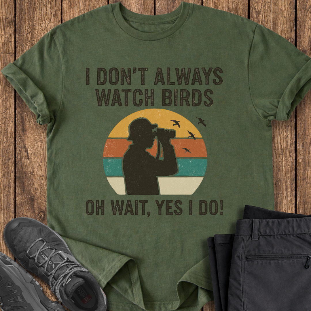 Green t-shirt with a graphic and text on a wooden surface, accompanied by shoes and pants.