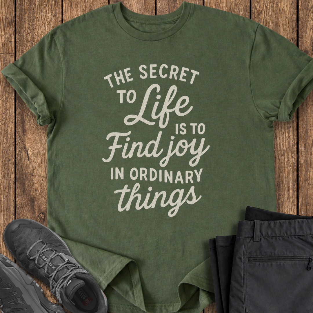 Green t-shirt with motivational quote on a wooden surface with shoes and pants.