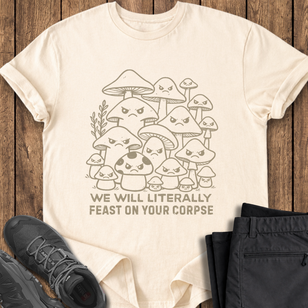 Beige t-shirt with mushroom graphic and text on a wooden surface with shoes and pants.