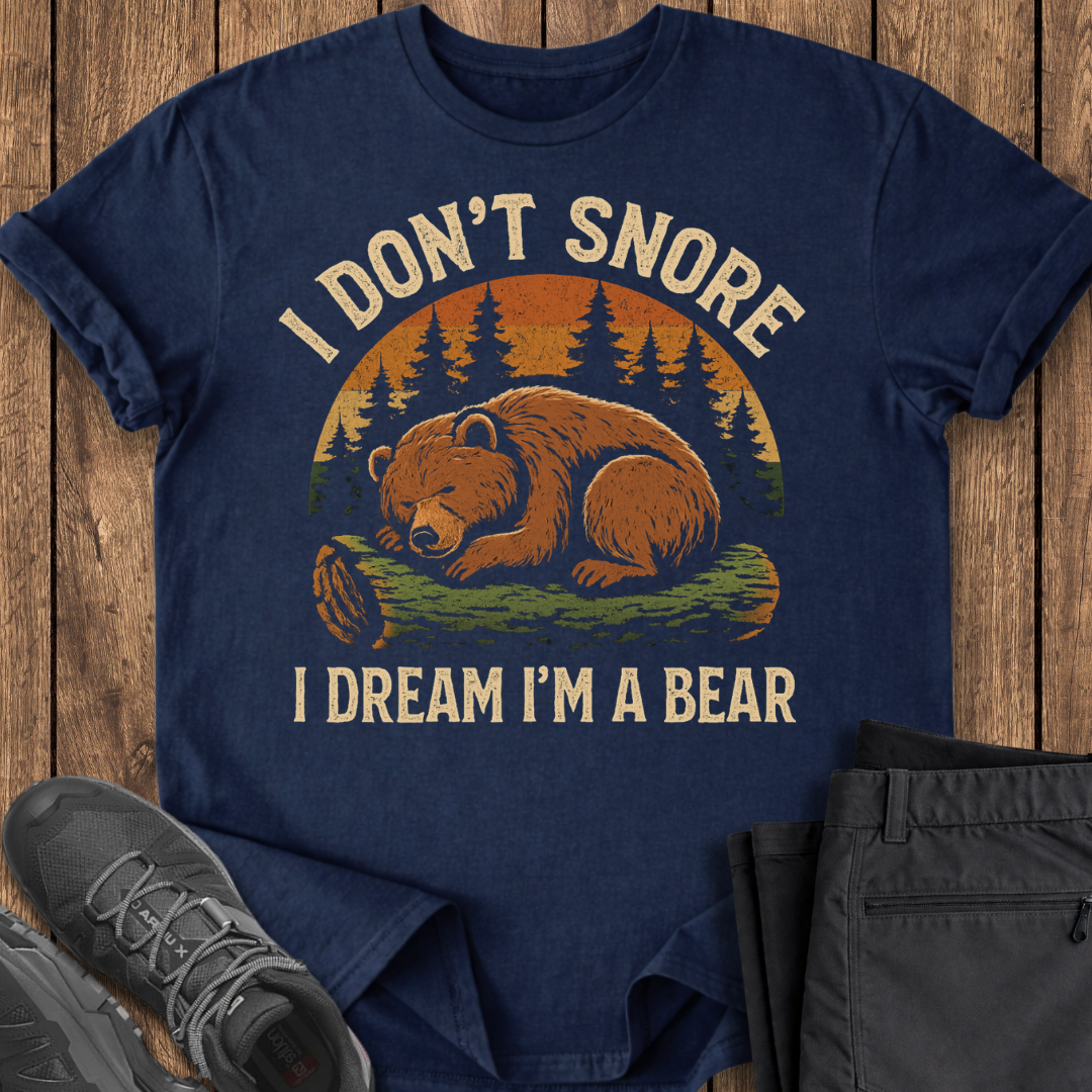 Navy blue t-shirt with bear graphic and text on a wooden surface with shoes and pants.