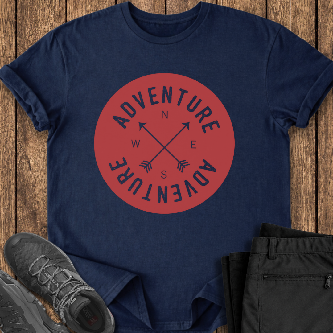 Navy blue t-shirt with red 'Adventure' graphic on a wooden surface with shoes and pants.