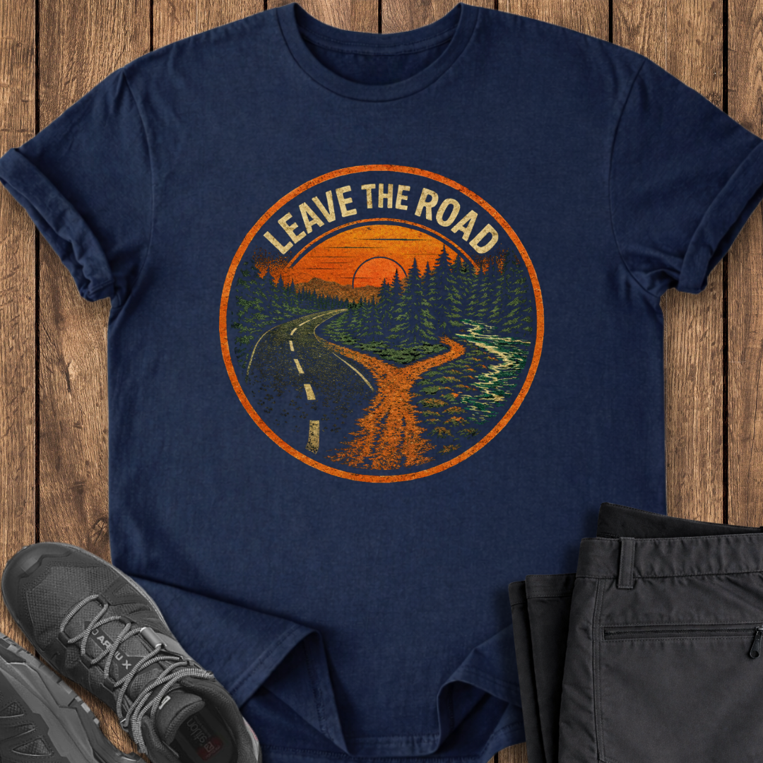 Navy blue t-shirt with 'Leave the Road' graphic on a wooden surface with shoes and pants.