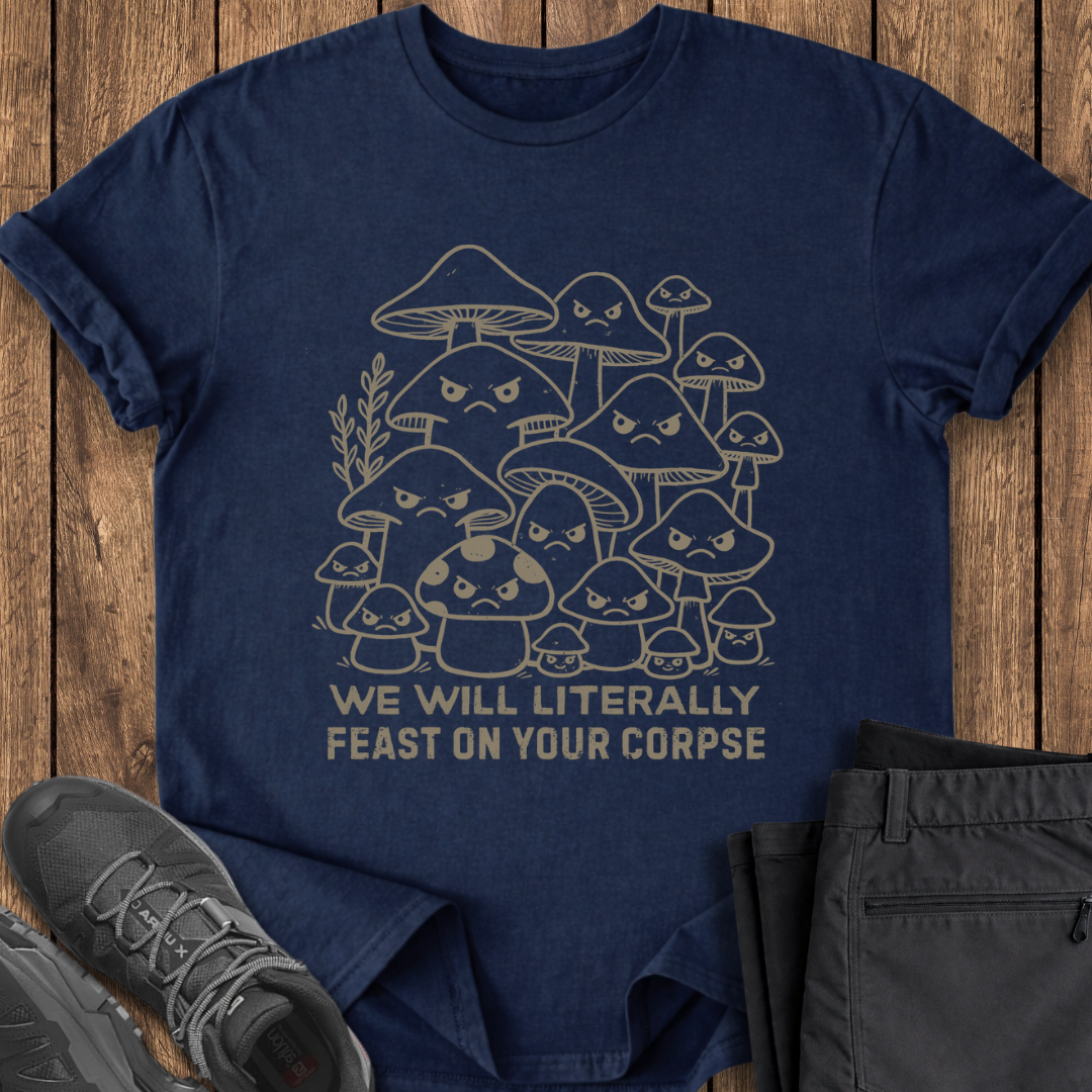 Navy blue t-shirt with mushroom graphic and text on a wooden surface, accompanied by shoes and pants.