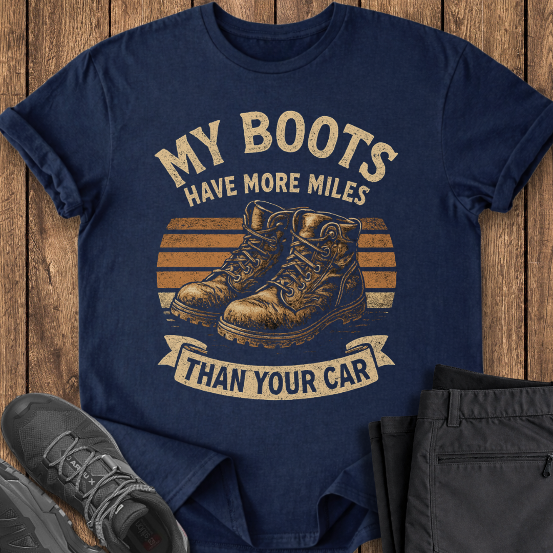 Navy blue t-shirt with graphic and text on a wooden surface, with shoes and pants for scale.