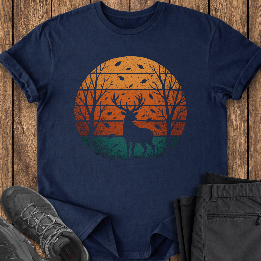 Navy blue t-shirt with a deer and sunset design on a wooden surface, with shoes and pants for scale.